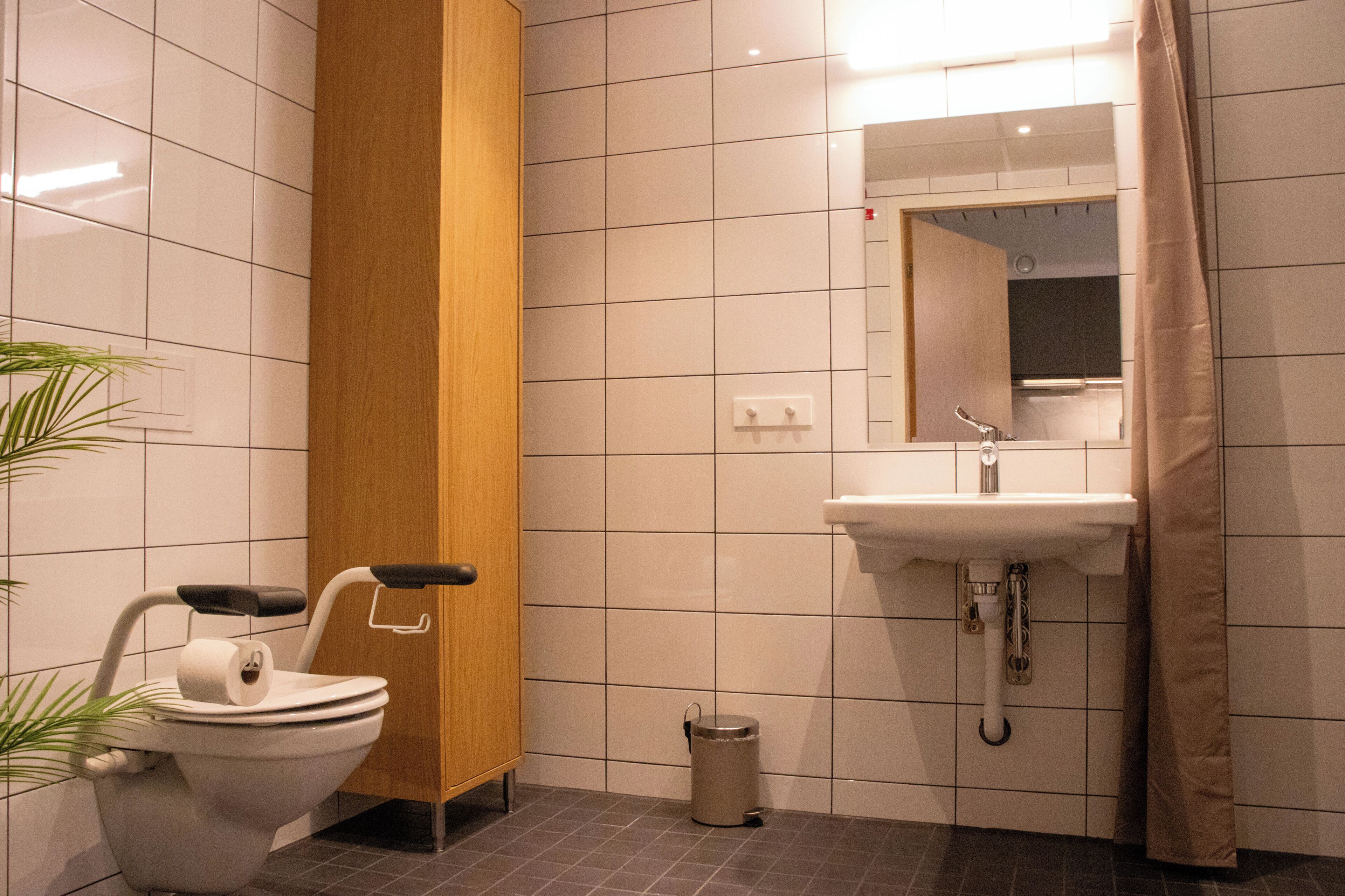 A bathroom with a toilet, sink, and mirror.