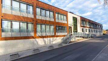 A modern building with large windows and a staircase leading to a second floor.