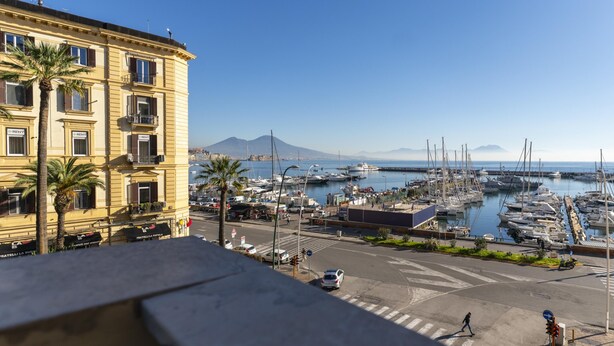 A marina with boats, a building with balconies, and a clear sky. - Piazza Sannazzaro 200 - Pop Art (Naples)