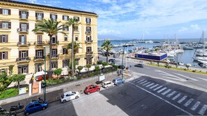 A coastal hotel with multiple floors, balconies, and a marina with boats in the background. - Piazza Sannazzaro 200 - Monet (Naples)