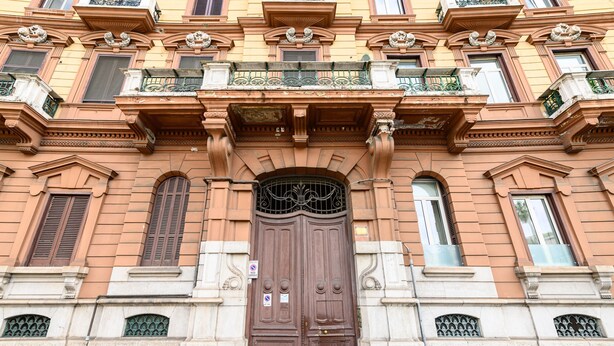 A historic building with a large wooden double door, ornate balconies, and decorative stonework. - Piazza Sannazzaro 200 - Monet (Naples)