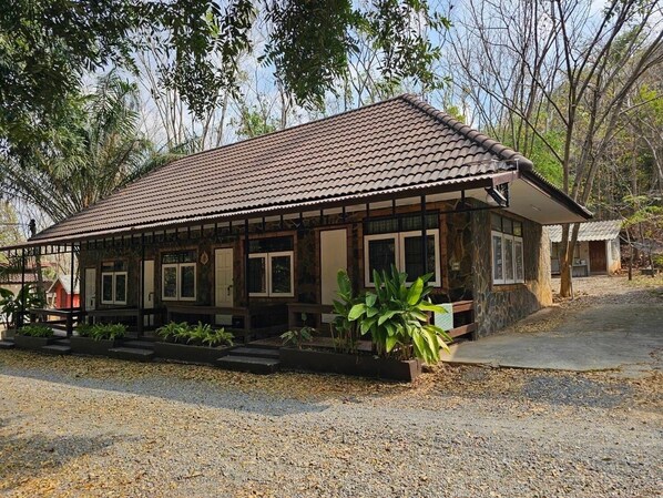 A rustic building with a tiled roof, wooden beams, and a gravel driveway. - Baan Rai Somkiat Homestay (Pak Chong)
