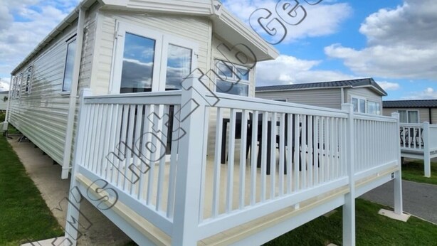 A mobile home with a white exterior, a covered porch, and a grassy yard. - 6 Berth luxury holiday home at Tattershall Lakes. Private Hot-Tub. Pet Friendly (Lincoln)