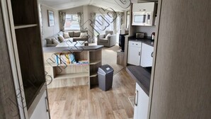 A compact living space with a kitchenette, a sofa set, and a small dining area. - 6 Berth luxury holiday home at Tattershall Lakes. Private Hot-Tub. Pet Friendly (Lincoln)