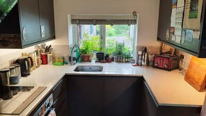 Eine Küche mit Fenster, Spüle und diversen Küchengeräten.