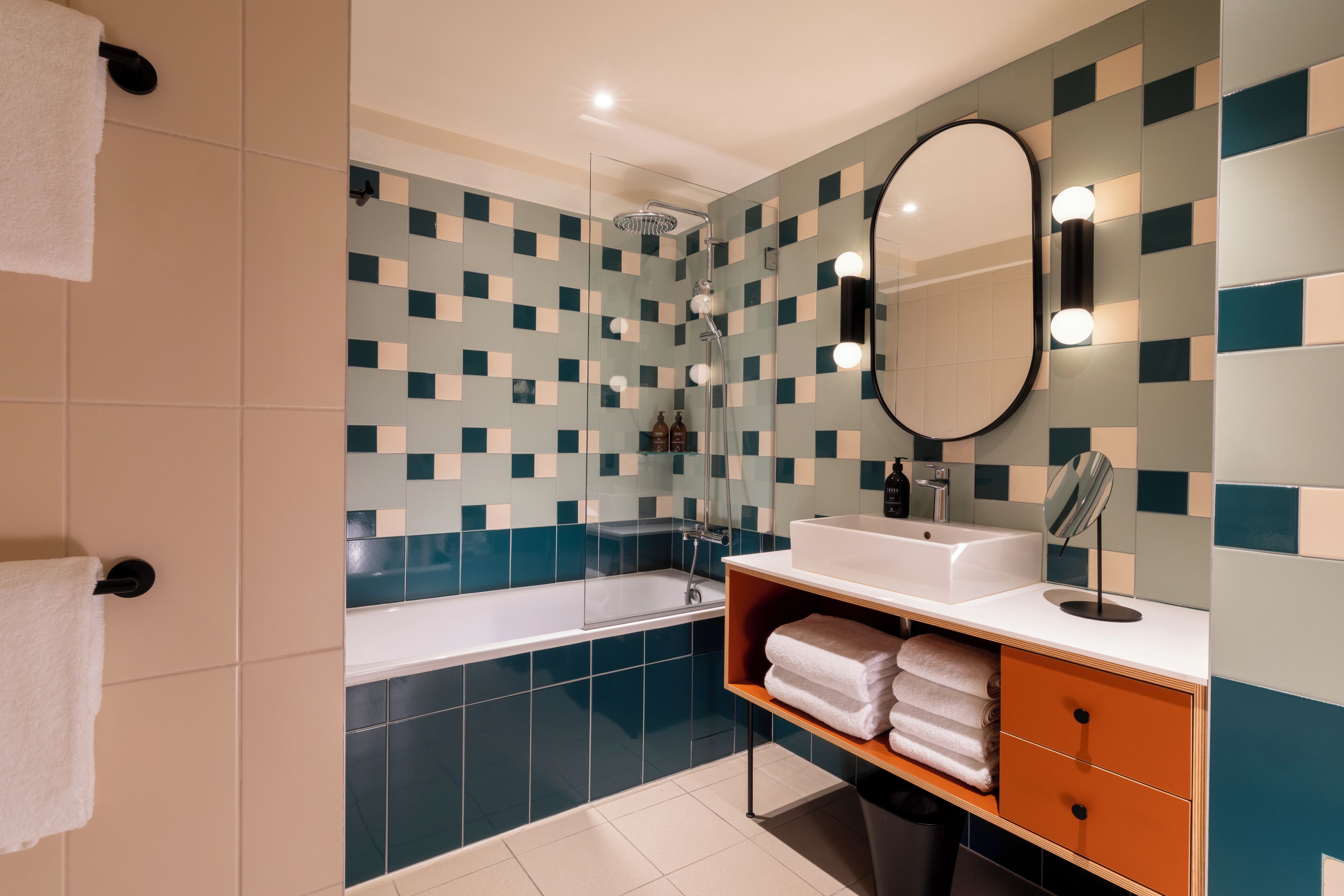 Ein modernes Badezimmer mit einer Badewanne, einem Waschbecken und einem Spiegel.