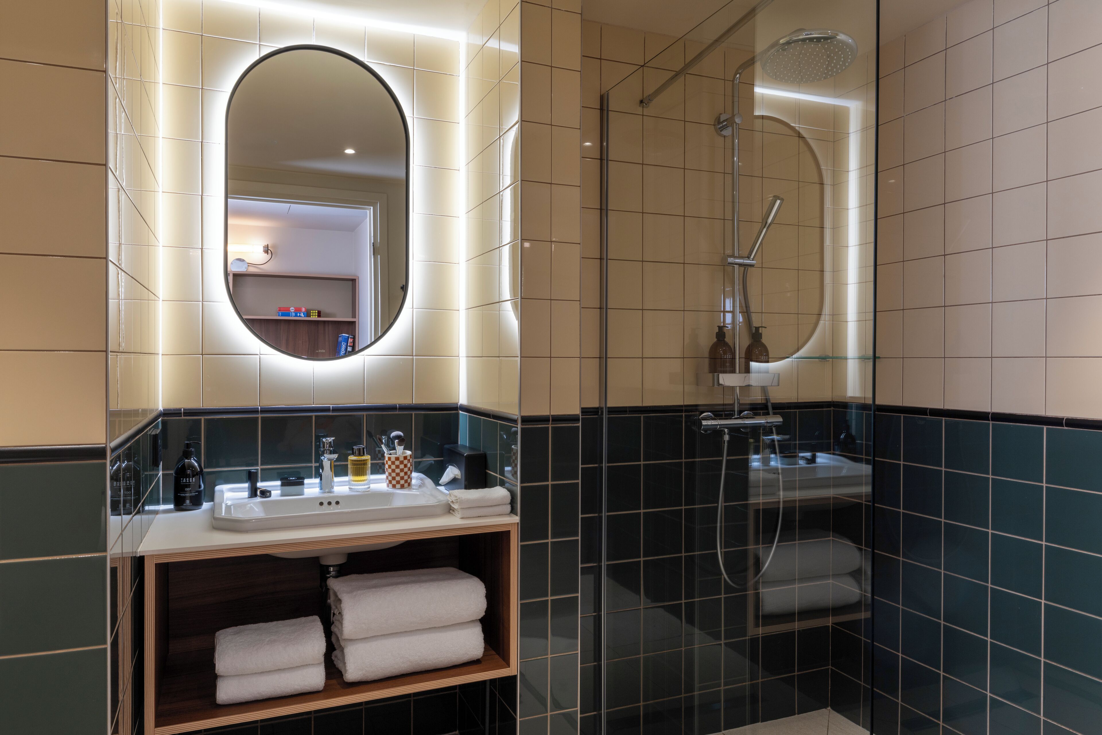 A modern bathroom with a sink, mirror, and shower.
