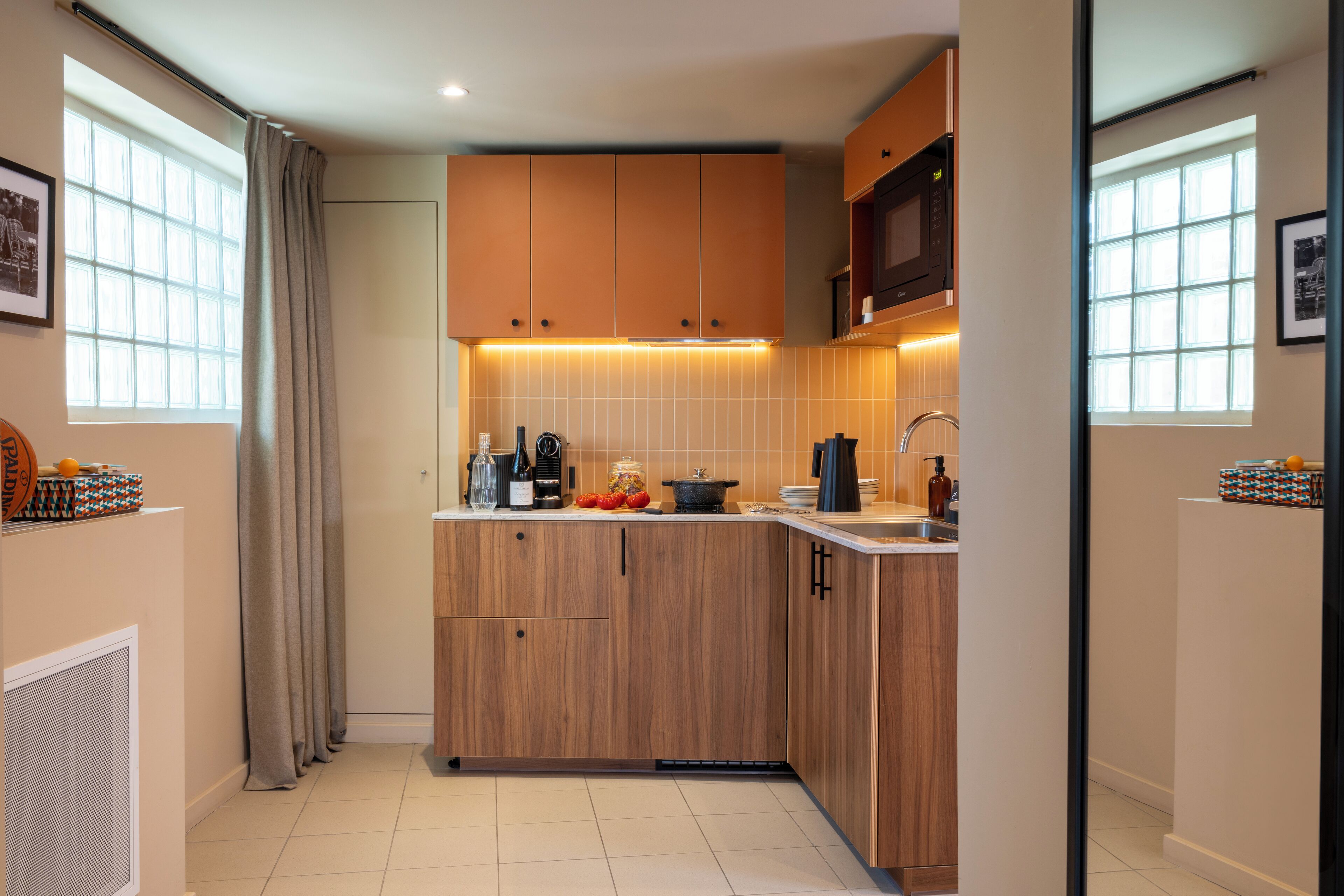 Une cuisine moderne avec des meubles en bois, un four à micro-ondes et un évier.