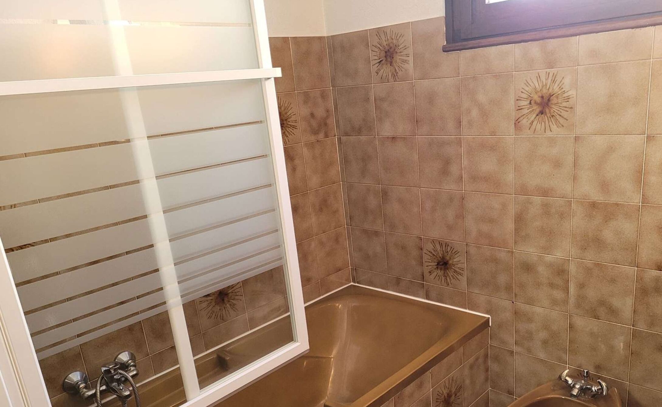 A bathroom with a bathtub, a shower, and a sink.