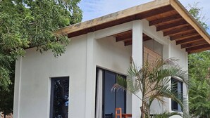 Una casa moderna con techo plano, ventanas grandes y un porche cubierto.