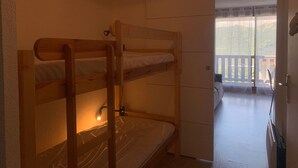 A bunk bed room with a door leading to a balcony with a view of a mountain. - Renovated studio in Pra Loup with balcony and wifi, close to cable car (Pra-Loup)