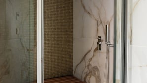 A shower area with a bench, a glass door, and a tiled wall. - Hestia - Kolokotroni 23 (Athens)