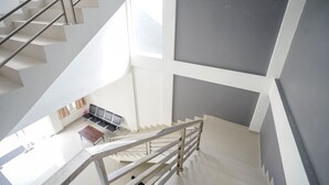 En modern inredning med en trappa, en sittgrupp och ett stort fönster.