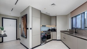 A modern kitchen with built-in appliances, a large window, and a minimalist design.