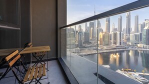 A balcony with a view of a city skyline and a body of water.