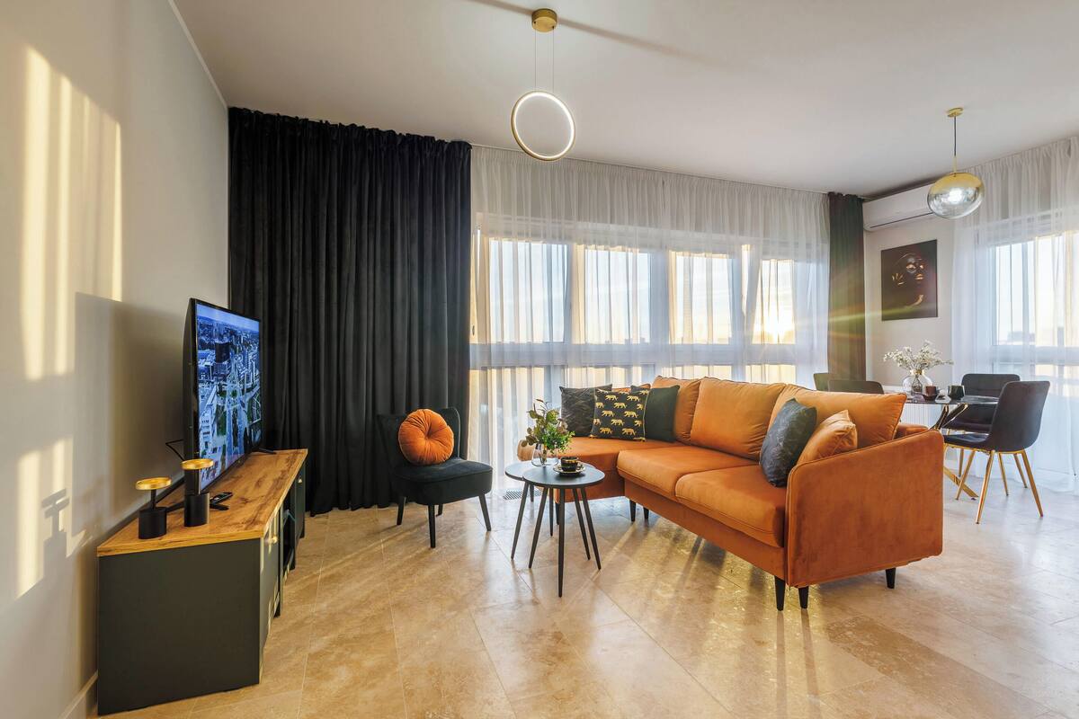 A modern living room with a sofa, a coffee table, and a TV on a wooden stand.