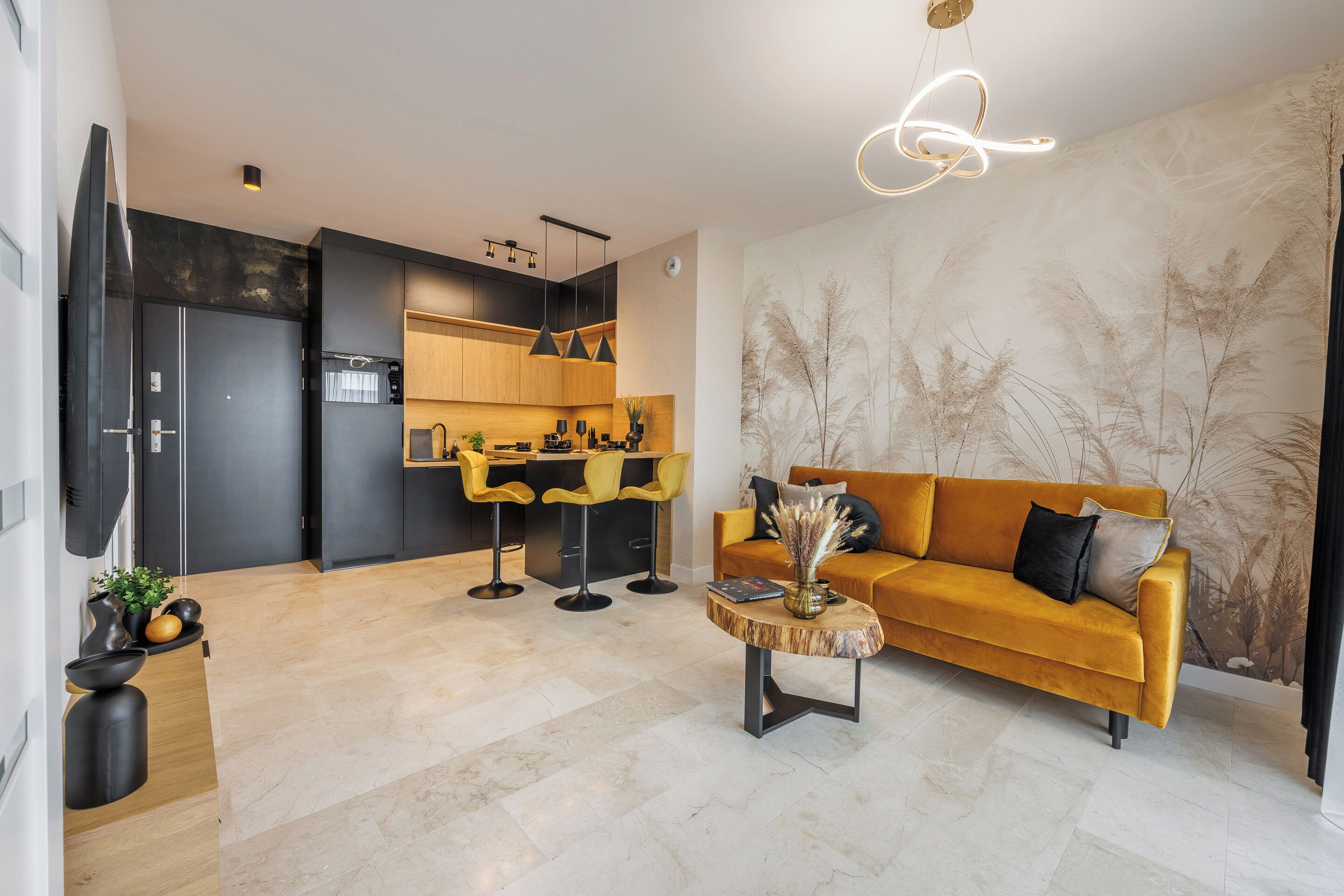 A modern living room with a sofa, coffee table, and a kitchen area with bar stools.