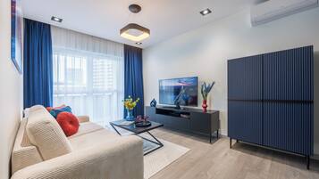 A modern living room with a sofa, a coffee table, a TV, and a large cabinet.