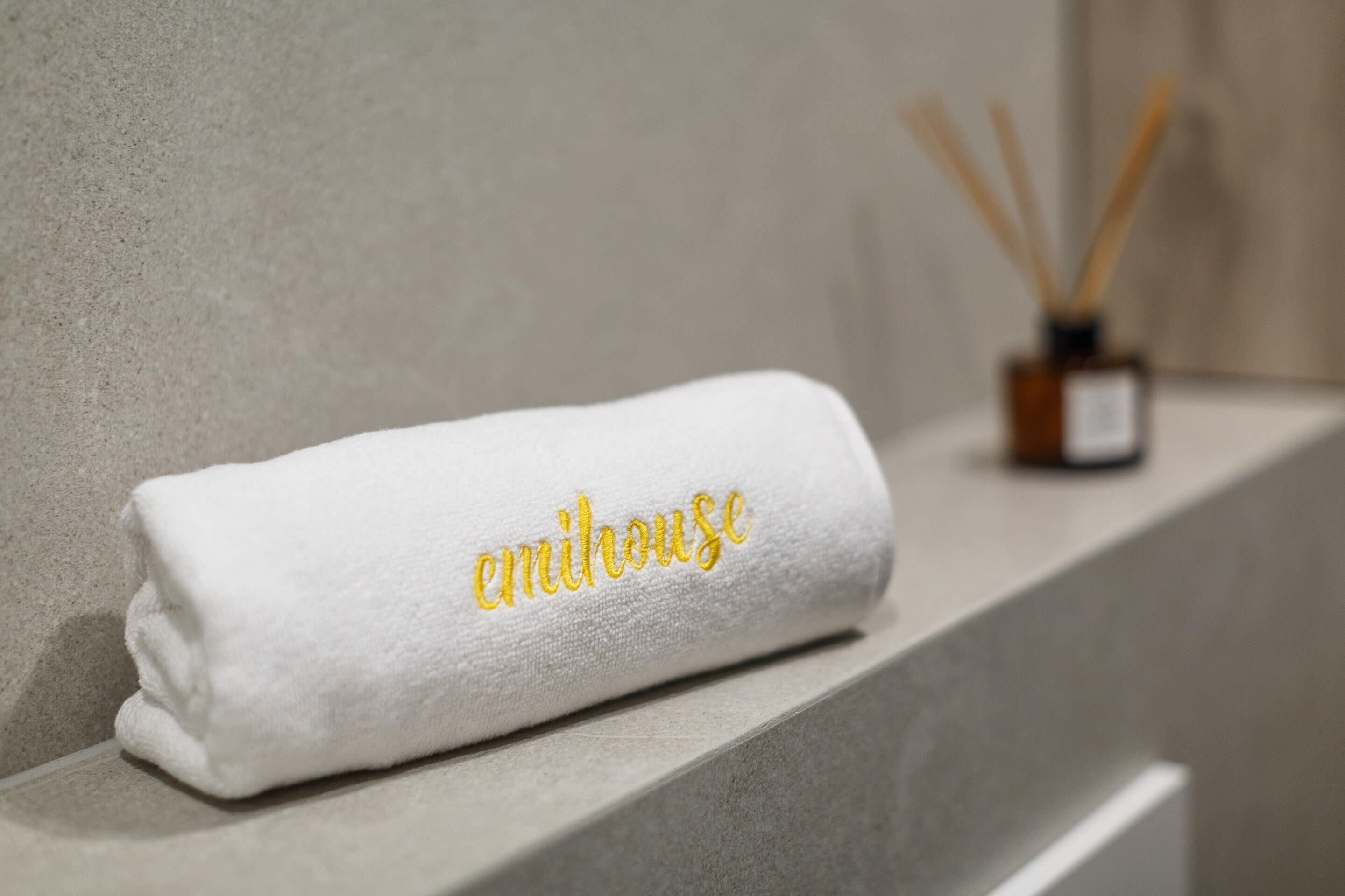 Una toalla blanca con texto bordado sobre un mostrador de baño.