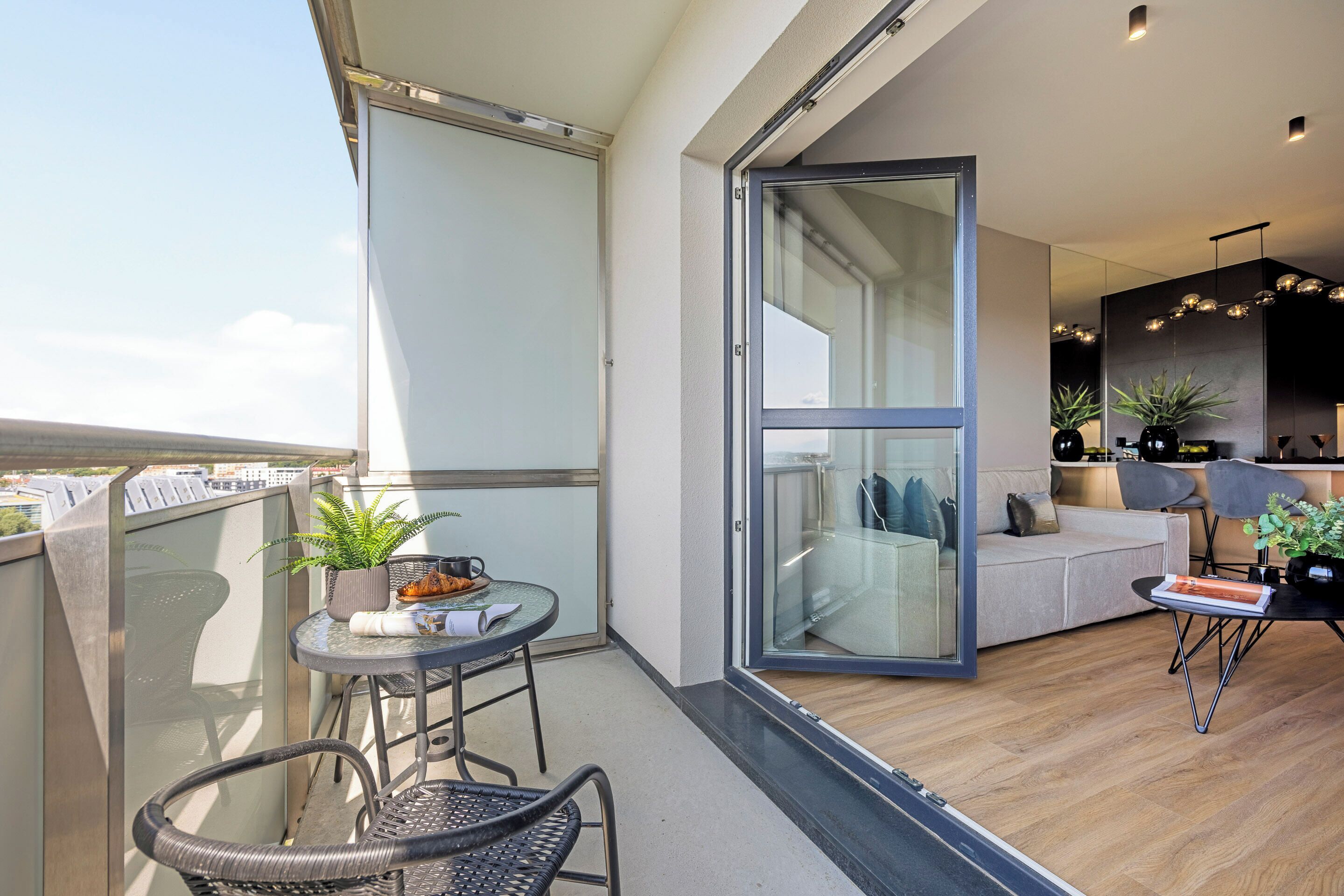 Un apartamento moderno con balcón, comedor y sala de estar.