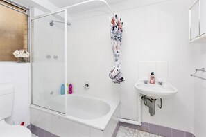 A bathroom with a glass-enclosed shower, a white sink, and a toilet. - Urban Chic Studio by 'the Strip' (Victoria Park)