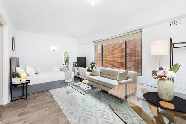 A modern living room with a sofa, coffee table, and a TV. - Urban Chic Studio by 'the Strip' (Victoria Park)