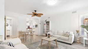 Un salon moderne avec un canapé, une table basse et un coin repas avec des chaises.