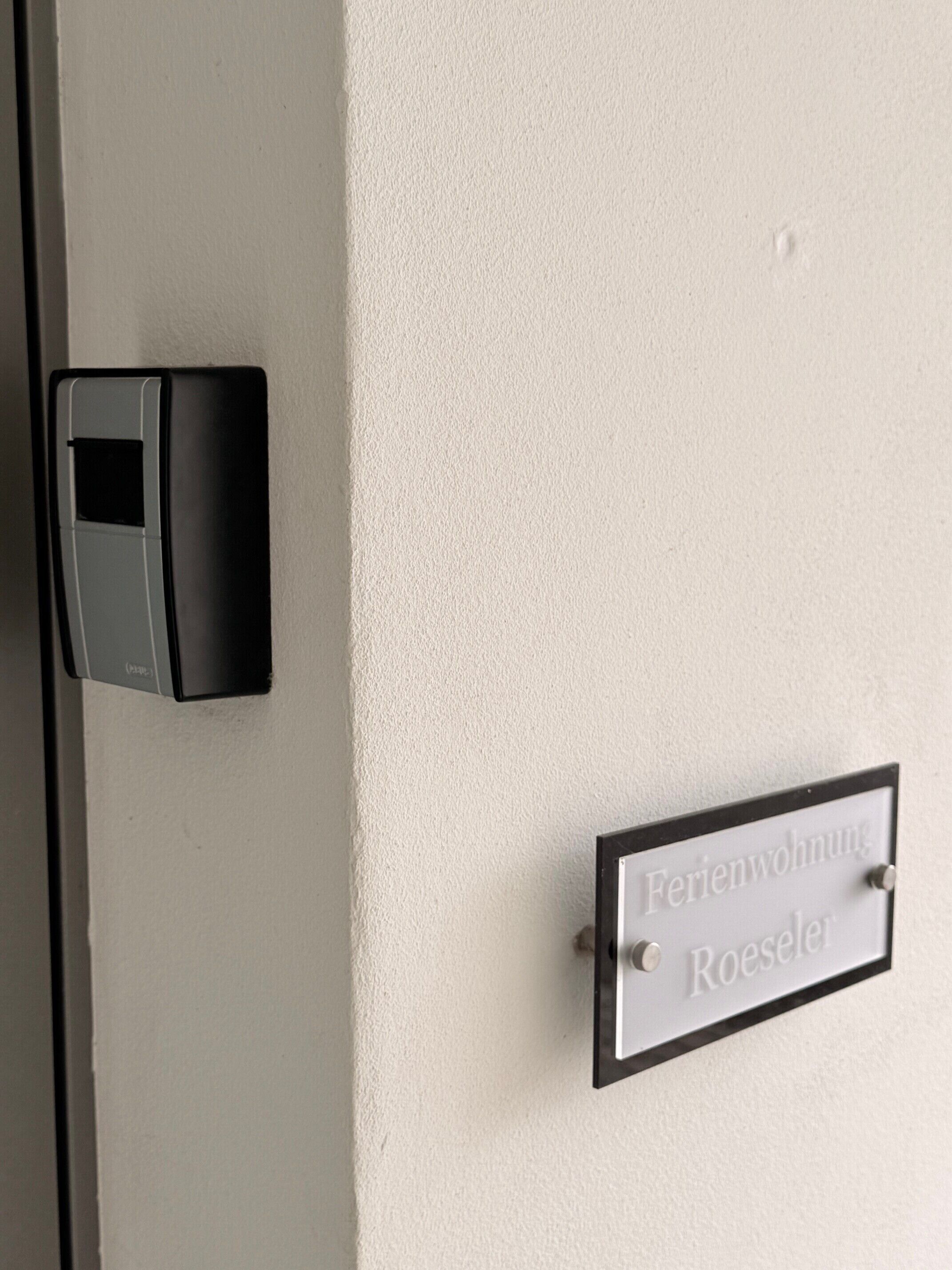 Een deur met een digitaal slot en een naambordje met de tekst 'Feriendorf Roesler'.