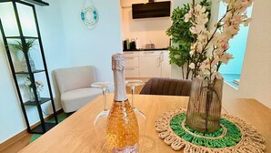 A dining table with a bottle of Pizzolato wine, a decorative vase with flowers, and a crocheted placemat.