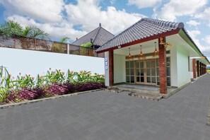 A modern building with a tiled roof, a covered entrance, and a sign that reads "OYO". - OYO 2896 Uma Menuh Guest House Near Pantai Keramas (Perean Tengah)