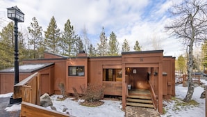 A modern wooden cabin with a covered porch and a staircase leading to the entrance. - Ridge Court # 14 at Palisades - Ski Shuttle, Dog OK (Olympic Valley)