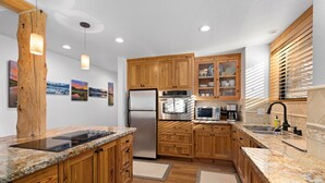 A modern kitchen with wooden cabinets, stainless steel appliances, and granite countertops. - Ridge Court # 14 at Palisades - Ski Shuttle, Dog OK (Olympic Valley)