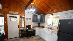 A compact kitchen with wooden cabinets, a stove, and a refrigerator. - Bear Paw- Lake Area  located in Willow Cove (Bass Lake)