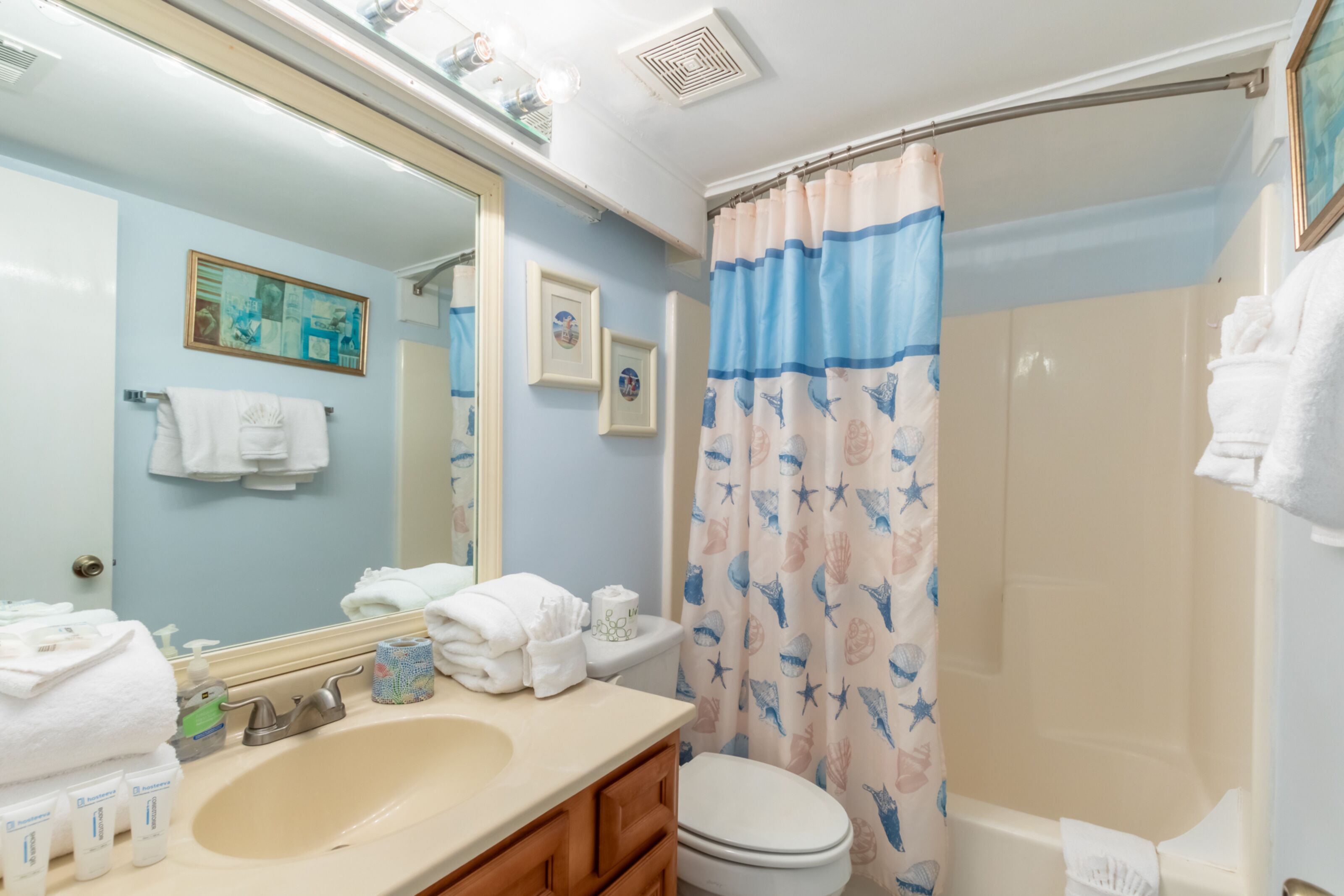 A bathroom with a sink, toilet, and shower curtain.