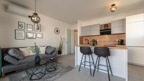 Eine moderne Küche mit Holzarbeitsplatte, zwei Barhocker und einem eingebauten Backofen.