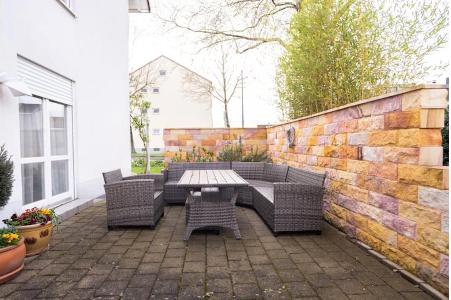 An outdoor patio with a built-in seating area and a table.