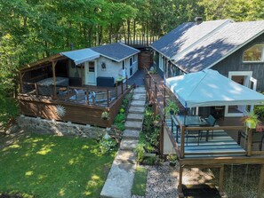 A cabin with a deck, a covered outdoor seating area, and a staircase leading to the main building. - Available exclusively for Winter 2027, from January 15 to March 13. Short or long stays for a peaceful getaway in the heart of the Laurentians. (Prévost)