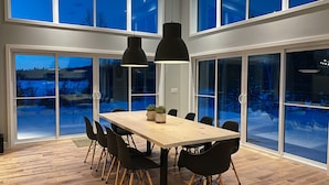 A modern dining area with a wooden table, black chairs, and pendant lights. - Magnificent chalet with a contemporary design: dream location for an unforgettable holiday (Notre-Dame-de-la-Merci)