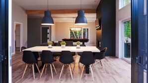 A modern dining area with a long table, black chairs, and pendant lighting. - Magnificent chalet with a contemporary design: dream location for an unforgettable holiday (Notre-Dame-de-la-Merci)
