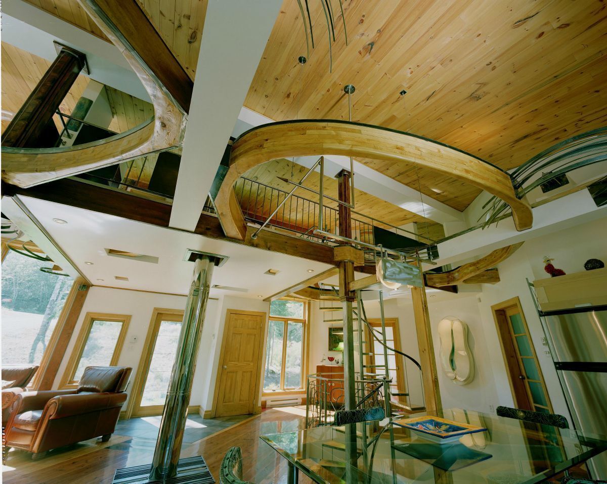 Ein geräumiger Innenraum mit einer Glasstaircase, Holzbalken und einer hohen Decke.