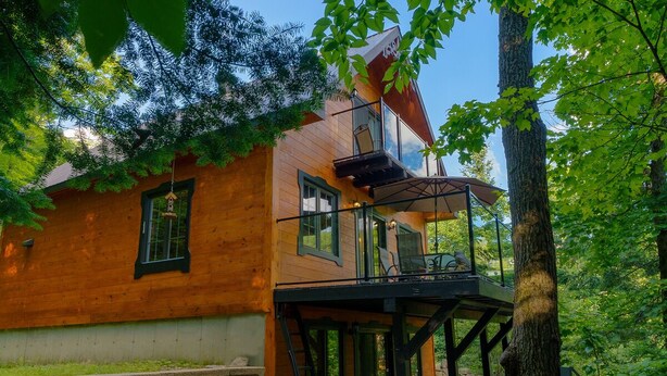 A wooden cabin with a hot tub, a balcony, and a deck. - Super cute cedar chalet surrounded by the forest with access to water (Entrelacs)