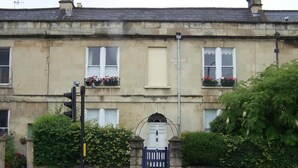 A two-story building with a traditional facade, a gated entrance, and a traffic light. - Stunning Georgian Spacious Apartment Central Bath (Bath)