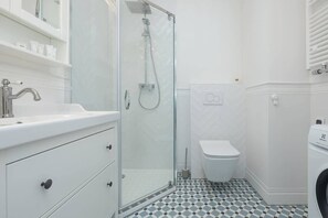 A modern bathroom with a glass-enclosed shower, a white sink, and a toilet. - Sunny Apartment | SPA and 100 m to the Beach (Rewal)