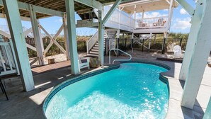 A swimming pool with a wooden deck and a covered area. - 5 Bedroom Oceanfront home with private pool! (Oak Island)