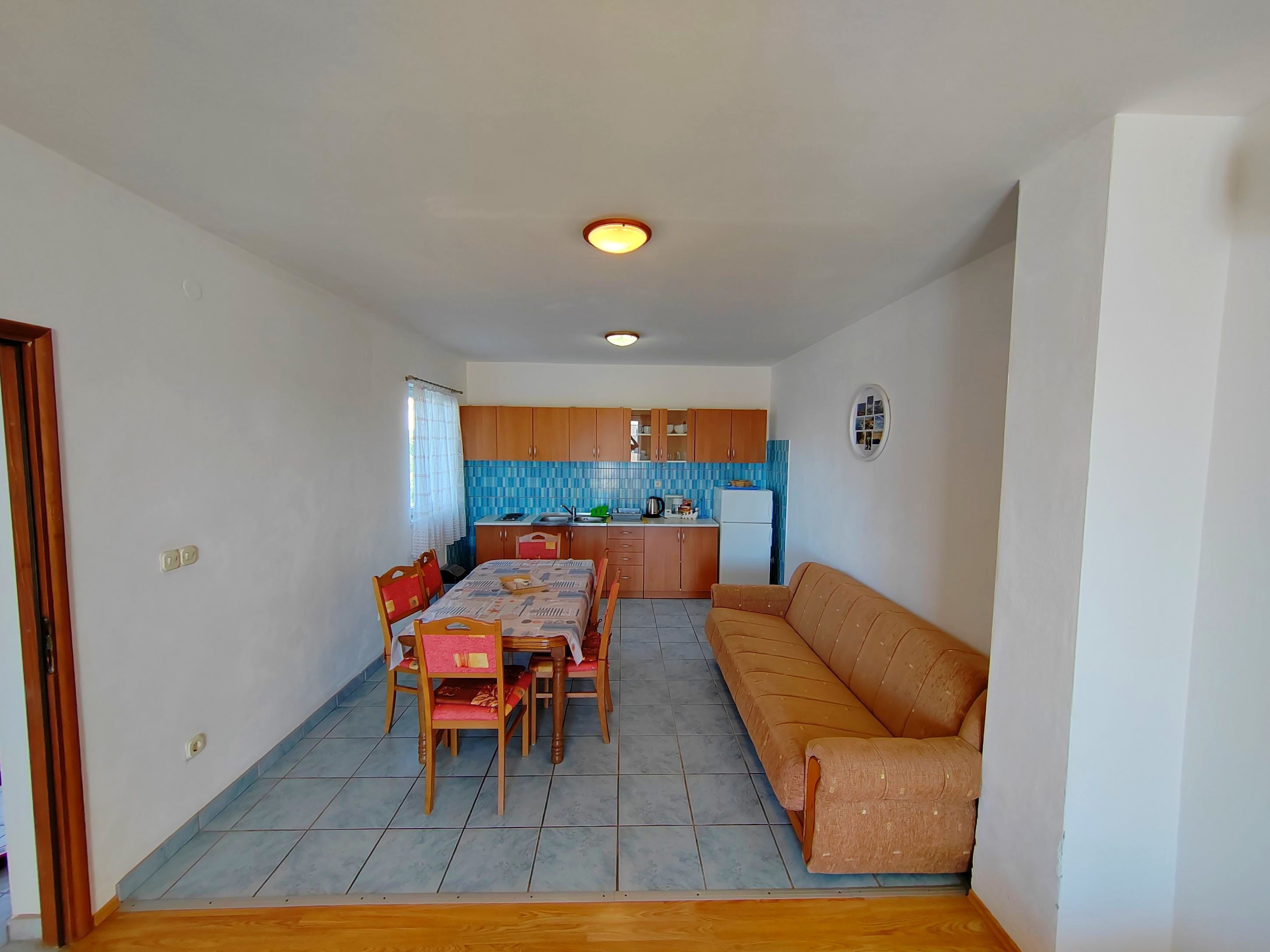A compact living space with a dining area, kitchenette, and a sofa.