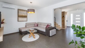 A modern living room with a sectional sofa, a round coffee table, and a pendant light.