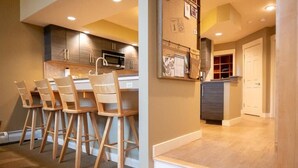 Una cocina moderna con sillas de madera, un microondas y un refrigerador.