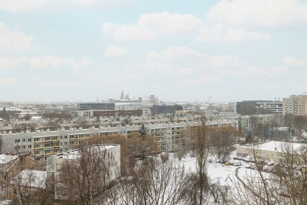 Un paisaje urbano con varios edificios, incluyendo una estructura moderna destacada y algunas edificaciones residenciales.