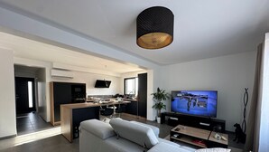 Una sala de estar moderna con un sofá grande, un comedor y una cocina.