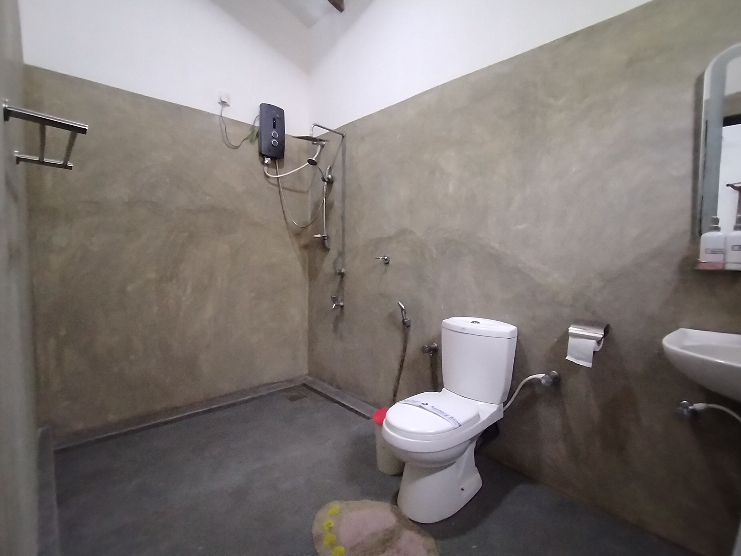 Une salle de bain avec des toilettes, un lavabo et une douche.
